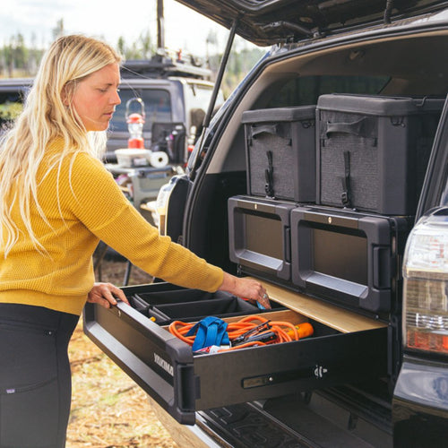 Woman organizing items in a car with MOD storage drawers